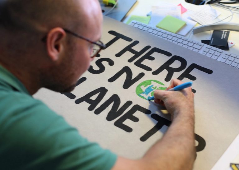 Man making a poster about the environment.