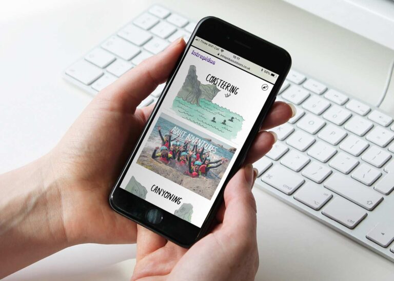 Person holing a phone, navigating through Intrepidus website, featuring different sections including coasteering, adult adventures and canyoning.