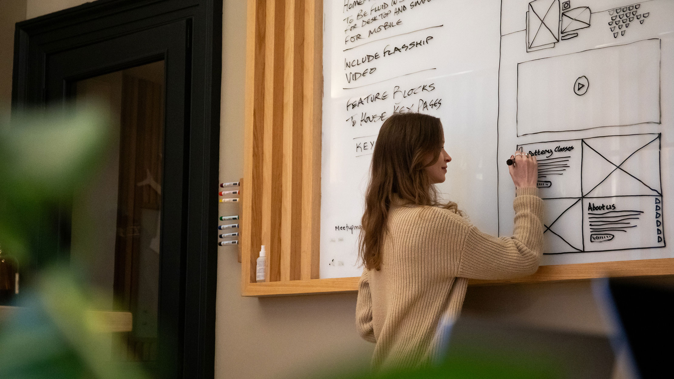 Firefly team member working on UX design sketch on a whiteboard.