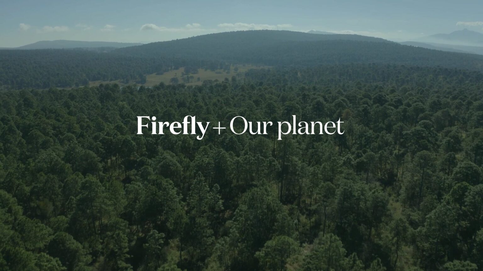 The words "Firefly + Our Planet" on a photograph of a lush forest.